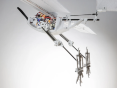 RAVEN, el dron inspirado en cuervos que utiliza patas para despegar Un dron experimental llamado RAVEN, inspirado en aves, mostrando sus patas mecánicas extendidas hacia atrás. El diseño incluye componentes expuestos como engranajes y electrónica visible, destacando un enfoque innovador en robótica basada en principios biológicos.