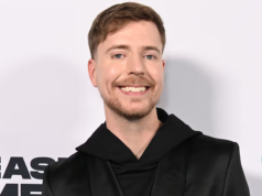 MrBeast se une a un grupo de inversores para comprar TikTok y evitar su prohibición Una persona sonriente con cabello corto y barba ligera, vestida con una prenda negra de estilo moderno, posando frente a un fondo claro con logotipos parcialmente visibles.