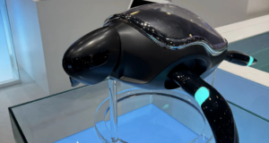 Fotografía de un robot en forma de tortuga marina llamado Beatbot Amphibious RoboTurtle, exhibido sobre una base de cristal en una vitrina iluminada, mostrando su diseño negro brillante con detalles azules.