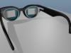 Gafas inspiradas en ojos de mosca para mejorar la visión de personas con degeneración macular Vista trasera de unas gafas inteligentes con un marco negro. Dentro de cada lente, se aprecian matrices rectangulares compuestas por pequeños puntos, que parecen ser pantallas o sistemas ópticos. El diseño incluye patillas gruesas que posiblemente albergan componentes tecnológicos.
