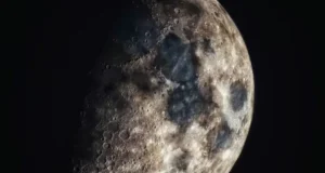 La Luna con una iluminación parcial, mostrando su superficie llena de cráteres y texturas geológicas. La imagen resalta las zonas oscuras y claras de la corteza lunar en contraste con el espacio profundo.