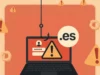 Ilustración de ciberseguridad que muestra un portátil con una alerta de peligro en la pantalla, un formulario de inicio de sesión y el dominio “.es”. Un anzuelo de phishing cuelga desde arriba, simbolizando un intento de robo de datos en dominios españoles. El fondo contiene múltiples iconos de advertencia.