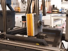 Atomic-6 lanza Space Armor, un escudo ligero y efectivo contra desechos hipersónicos en órbita Prueba de impacto balístico en un laboratorio, con un bloque protector dañado por proyectiles montado en una máquina de ensayo.