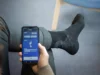 Calcetines inteligentes que permiten a diabéticos recuperar la sensibilidad en sus pies Persona usando calcetines inteligentes para diabéticos con sensores, controlados mediante una aplicación en un teléfono móvil.