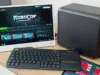 Casi el 90 % de los juegos de Windows ya funcionan en Linux Un pequeño setup de escritorio con monitor mostrando Steam y el juego RoboCop: Rogue City, acompañado de un teclado inalámbrico y un ordenador compacto sobre una mesa de madera.