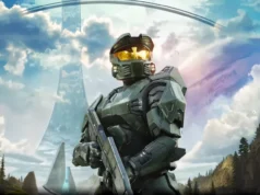 El diseñador de Doom acusa al ex jefe de Xbox Don Mattrick de cancelar el MMO de Halo por dinero Personaje de ciencia ficción con armadura verde futurista y visor dorado, sosteniendo un arma. Está de pie en un paisaje montañoso con estructuras metálicas gigantes en forma de anillo al fondo y cielo parcialmente nublado. La escena pertenece al universo del videojuego Halo.