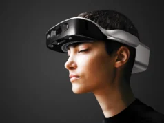 Estas gafas con IA hacen lo que un perro guía: el dispositivo que devuelve la independencia a personas ciegas Persona con un visor de realidad mixta de diseño futurista, visto de perfil, sobre fondo oscuro, representando el uso de tecnologías avanzadas de computación espacial y realidad aumentada.