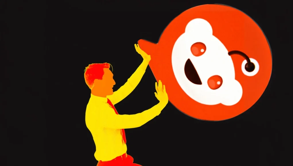 Ilustración de estilo pop art donde una figura humana en colores brillantes sostiene o empuja un gran logotipo de Reddit sobre un fondo negro.